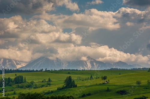 Spring green mountain landscape with meadows and rocky peaks. Landscape with a chapel and snow-covered Tatra Mountains in Kacwin, Malopolskie, beautiful Poland. © Ivan