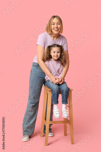 Child sitting on chair and her mother. Mother's Day