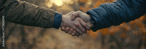 A detailed view of two individuals clasping hands in a close, intimate gesture photo