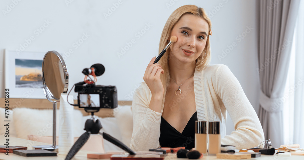 Young woman making beauty and cosmetic tutorial video content for social media. Beauty blogger smiles to camera while showing how to beauty care to audience or followers. Panorama Blithe