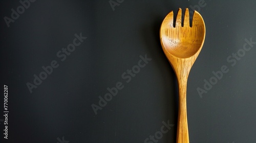 Minimalist Wooden Spork on Dark Background, Modern Kitchen Utensil Concept photo