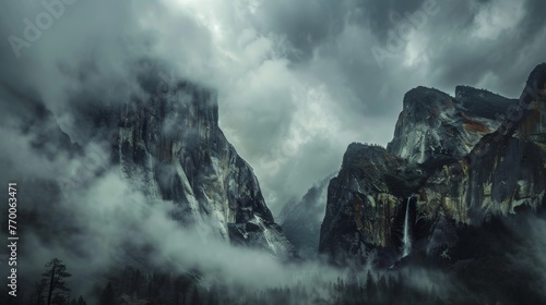  A mountain shrouded in mist and clouds, with a waterfall cascading from its peak, occupies the center of the photo © Olga