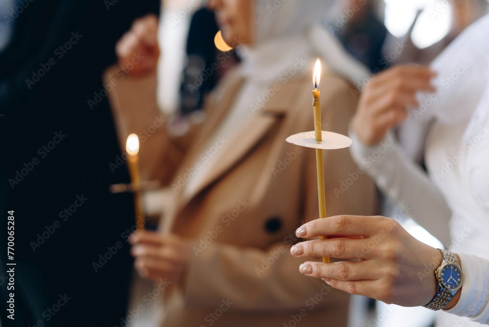 hand with church candle - obrazy, fototapety, plakaty 