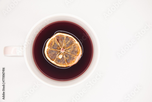 Xícara de chá de Hibisco, vermelho com rodela de laranja desidratada no chá. Tons de vermelho, branco e amarelo, alaranjado, fundo branco. Acidez. Fundo branco. photo