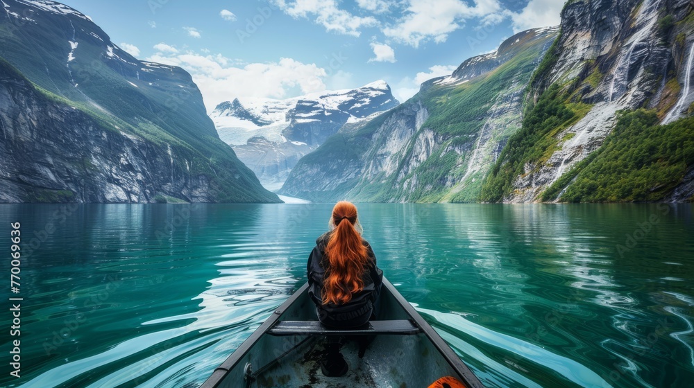  Woman in boat amidst water, surrounded by mountains and blue sky