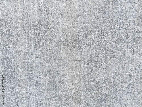 Close-up of a light gray concrete surface. The smooth texture of the concrete has a mottled appearance with slight variations in color