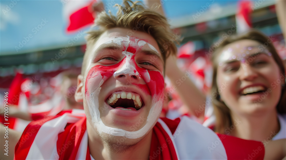 A cheerful fan of the national team with a cheering crowd in the background.