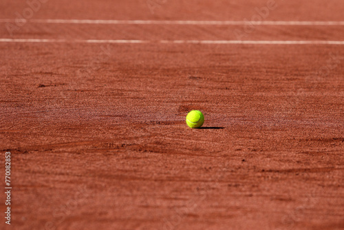 Detail of a tennis ball stopped on the ground of a clay tennis court during a sunny day © Vamos Sports Prod