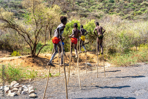 Ethiopia, near Key afer, boys from the Banna tribe walking on stilts.   photo