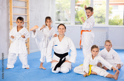Portrait of female karate or judo coach with her students little children in the gym
