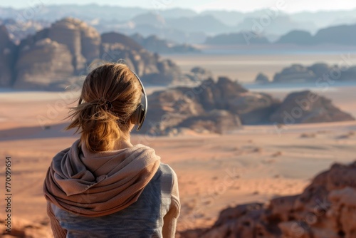 A traveler enjoys tranquil music while contemplating the vast expanse of a serene, sandy desert landscape