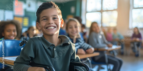 Cheerful preteen boy sitting in a wheelchair in a classroom in school. Disabled child learning new skills with his typical peers. Education for special needs children.