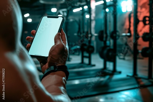Close-up of a smartphone being used by an individual in a gym, showcasing the link between technology and modern workout routines photo