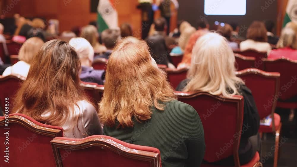 Female participants audience at the symposyum meeting, attendees in conference room hall listens to lecturer, group of women on a congress together listen to speaker on a stage at master-class Female participants audience at the symposyum meeting, attendees in conference room hall listens to lecturer, group of women on a congress together listen to speaker on a stage at master-class