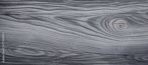 A close up of a hardwood piece of flooring with a grey patterned knot, resembling a dark rectangle with electric blue liquid running through it