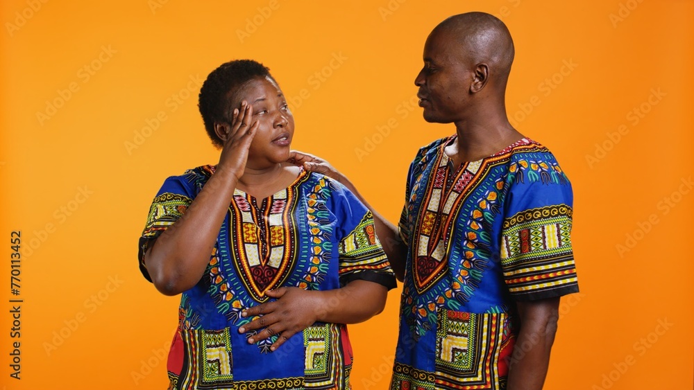Obraz premium Tired husband and wife dealing with migraine on camera, being in pain and rubbing temples to ease tension. African american married couple feeling sick with painful headache, overworked.