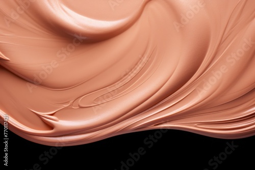 A creamy swatch of makeup is elegantly smeared against a smooth, neutral-toned backdrop.