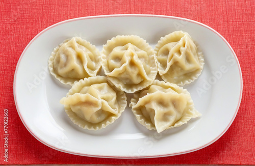 Dumplings filled on red plate, cut out on white background