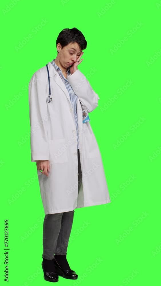 Side view Tired general practitioner yawning and feeling overworked after night shift at hospital, exhaustion and work pressure. Medic being tired and experiencing burnout against greenscreen. Camera Side view Tired general practitioner yawning and feeling overworked after night shift at hospital, exhaustion and work pressure. Medic being tired and experiencing burnout against greenscreen. Camera