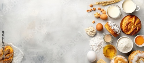 Baking and cooking various baked goods such as bread, pastry, or cake with ingredients like flour, sugar, milk, eggs, coconut, and butter placed on a bright grey background with space for text, photo