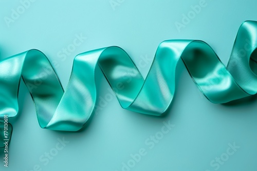 A long, green ribbon is curled up on a blue background