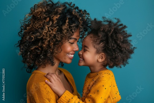 A mother and daughter are hugging each other in a yellow sweater