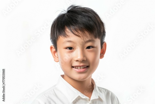A young boy with short hair and white shirt is smiling