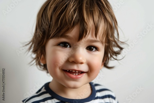 Portrait of a smiling little boy on a gray background. Close-up.