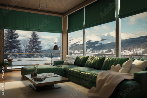 Modern living room interior with green leather sofa, coffee table, and large windows with a view of the snow-capped mountains.