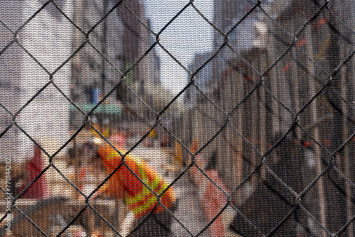New York construction site fence blurred worker in robe