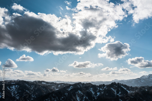 ドローン写真：雪が溶けつつある山と、広がる青空と雲