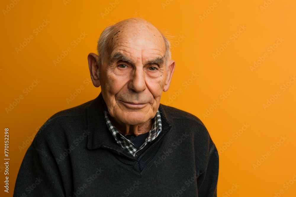 Portrait of an elderly man on a yellow background. Studio shot. Portrait of an elderly man on a yellow background. Studio shot.