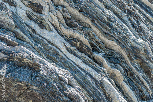 Nature force compressed prominent cracked rock layers structure formation details, in various shapes, colors, thicknesses, at south central coast of Crete, Greece. Nature Geological science concept.