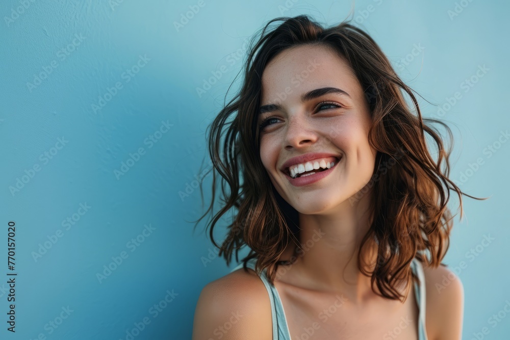 beautiful smiling young woman looking at camera, isolated on blue background beautiful smiling young woman looking at camera, isolated on blue background