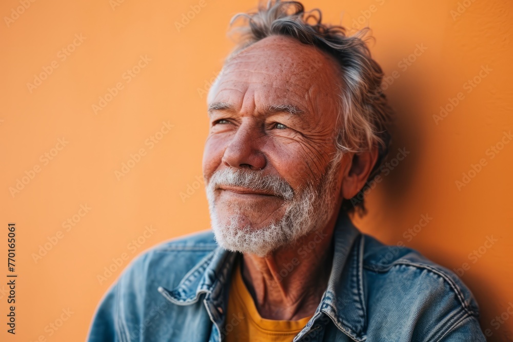Portrait of a senior man with gray hair and beard against orange wall Portrait of a senior man with gray hair and beard against orange wall