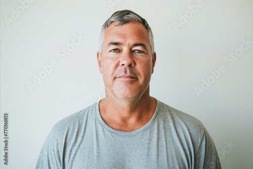 Portrait of handsome mature man with grey t-shirt looking at camera © Inigo