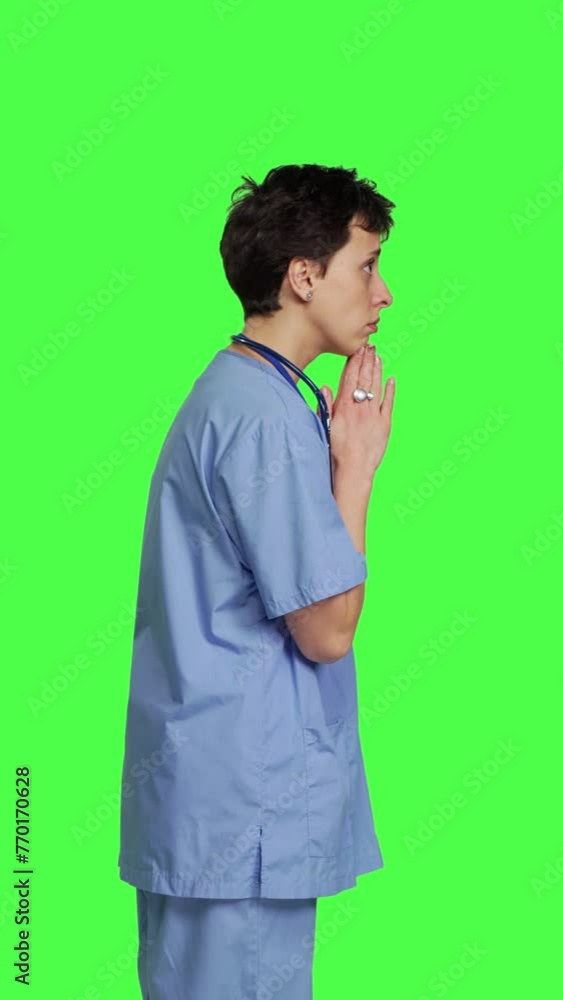 Profile Medical assistant being hopeful praying for good luck against greenscreen, holds hands in a prayer sign and having belief in spirituality. Young christian nurse with faith in meditation Profile Medical assistant being hopeful praying for good luck against greenscreen, holds hands in a prayer sign and having belief in spirituality. Young christian nurse with faith in meditation