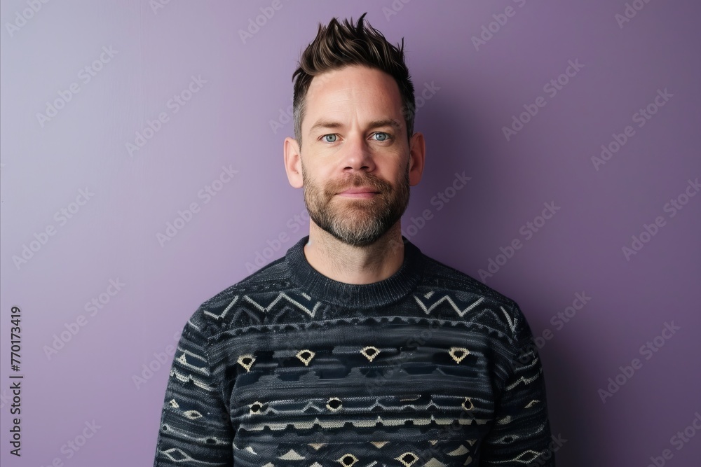 Portrait of a handsome young man with beard and mustache wearing sweater against purple background Portrait of a handsome young man with beard and mustache wearing sweater against purple background