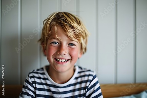 Portrait of a smiling little boy with blond hair looking at camera
