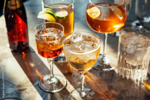 Assorted cocktails on a sunny table setup - A vibrant display of various cocktails with garnishes on a table bathed in sunlight highlighting the drinks' colors