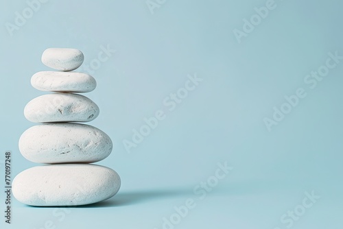 Photo of A stack of white rocks on light blue background symbolizing balance and tranquility for selfcare product advertising