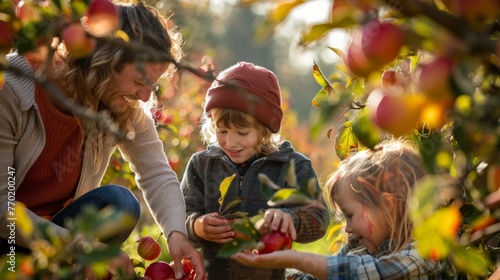 A happy family picking apples at an orchard during a beautiful autumn day.