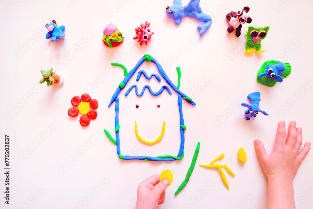 Child sculpting plasticine house like Earth planet, flower and animals. Homework for earth day. Protection of environment. Ecology concept. Concept of creative learning for preschoolers