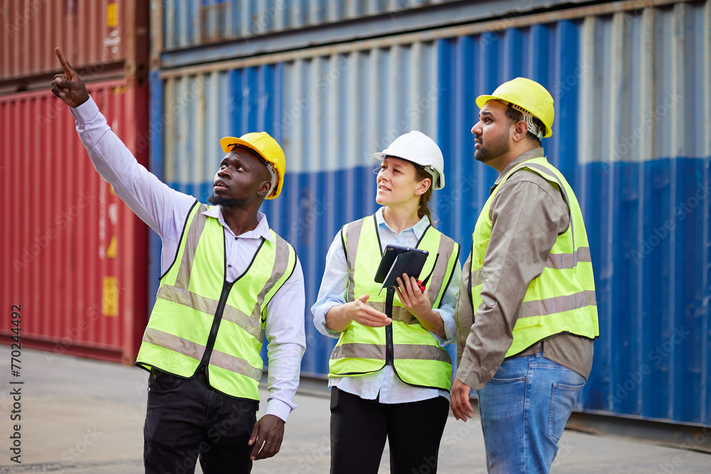 workers working on tablet for checking product and pointing at containers warehouse storage workers working on tablet for checking product and pointing at containers warehouse storage