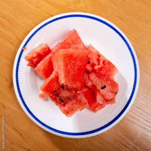 Service plate containing fresh watermelon pieces with other table appointments