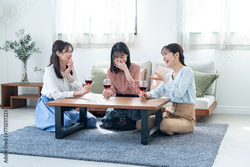 自宅で赤ワインを飲む日本人女性３人
