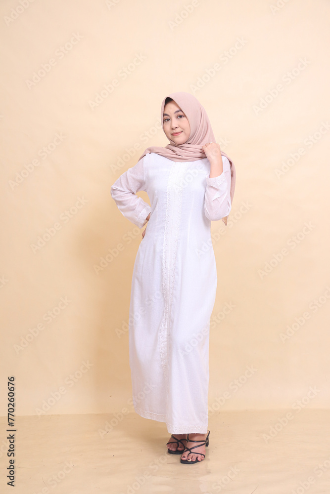 full body woman indonesia wearing beautiful dress smiling pose holding waist and shoulders isolated on cream background - beauty, model, studio and fashion concept full body woman indonesia wearing beautiful dress smiling pose holding waist and shoulders isolated on cream background - beauty, model, studio and fashion concept