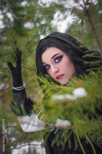 Beautiful young enchantress walking in the winter forest. photo