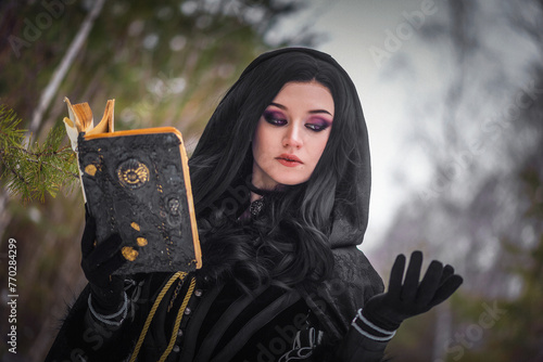 Fototapeta Beautiful young enchantress walking in the winter forest.