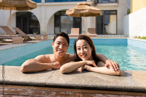 Happy young couple relaxing in swimming pool photo
